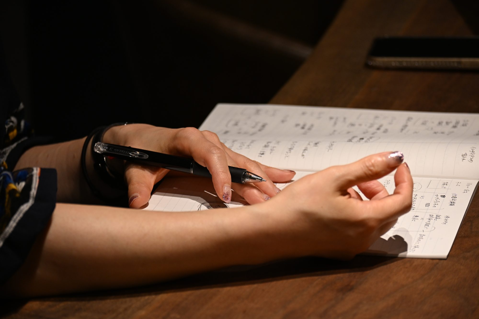 書き込みのあるノートと受講生の手元