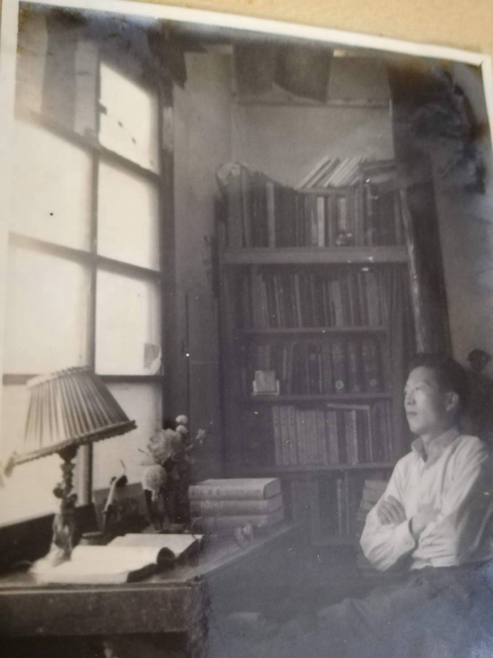 書斎の本棚の前に座る代表の父